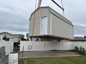 High barn prefab shed installation by crane in Lethbridge backyard